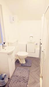 a white bathroom with a toilet and a sink at Peaceful, Cosy and Central Stay in Nottingham in Nottingham +6 photos