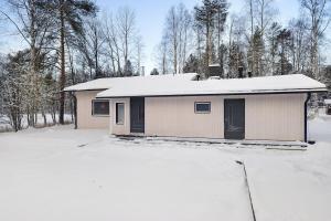 una casa con techo cubierto de nieve en la nieve en Villa Lapland Luxe, Private Sauna, Free Wifi, en Rovaniemi