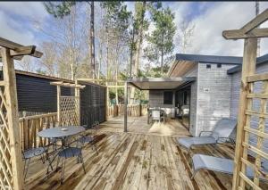 a patio with a table and chairs on a wooden deck at Le Cottage de Laura Jullouville 6 pers in Jullouville-les-Pins