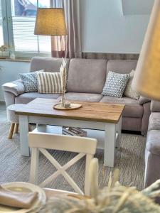 Una sala de estar con un sofá y una mesa de café. en Wenkendeck, en Fehmarn