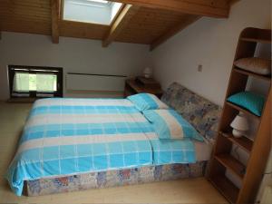 ein Schlafzimmer mit einem Bett mit einer blau-weißen Bettdecke in der Unterkunft Ferienwohnung für 7 Personen ca 138 m in Slap ob Idrijci, Küstenland Slowenien in Slap ob Idrijci + 13 Fotos