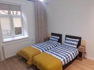ein Schlafzimmer mit einem Bett mit einer blau-gelben Decke in der Unterkunft Studio przy Szpitalu in Stettin