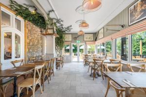 a restaurant with tables and chairs and windows at Sidcot Arms in Winscombe +34 photos