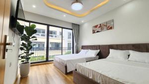 ein Schlafzimmer mit zwei Betten und einem großen Fenster in der Unterkunft Timi Homestay Near the Wave Park Ocean Park 2 in Hòa Bình + 12 Fotos