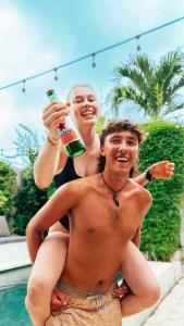 une femme est assise sur un homme dans l'établissement Lay Day Hostel Canggu, à Canggu