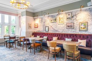 a restaurant with tables and chairs and a bench at Sidcot Arms in Winscombe
