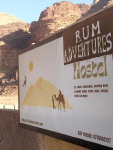 a sign in the desert with a camel and a mountain at Rum Adventures Hostel in Wadi Rum