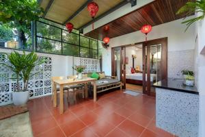 une salle à manger avec une table et une chambre dans l'établissement Red Flower Cottages Homestay, à Hội An