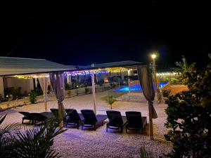 a group of chairs and umbrellas at night at Apartments Diva Flamingo in Barber