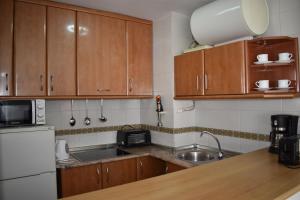a kitchen with wooden cabinets and a sink at Zentral Gelegene Wohnung in Cómpeta