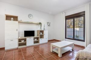 un salon avec une télévision et un canapé dans l'établissement Brisa Marina, à Chiclana de la Frontera