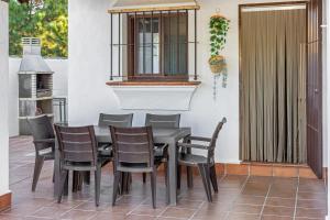 Une table à manger et des chaises sont disponibles sur la terrasse. dans l'établissement Brisa Marina, à Chiclana de la Frontera