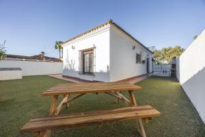 un banc de pique-nique en bois installé sur une pelouse devant un bâtiment dans l'établissement Brisa Marina, à Chiclana de la Frontera