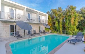 - une piscine avec des chaises et des parasols à côté d'une maison dans l'établissement Villa Arborea by Villas Guide, à Molunat
