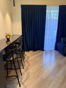 ein Zimmer mit blauen Vorhängen und einem Tisch und Stühlen in der Unterkunft Sea Breeze Park Residence 1 in Nardaran + 1 Foto