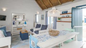 ein Wohnzimmer mit einem Tisch und einem Korb darauf in der Unterkunft Zandtorini Seaside Cottage in Struisbaai