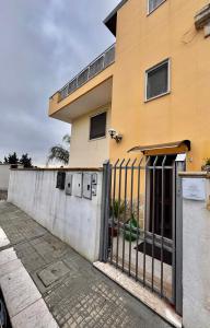 un edificio amarillo con una puerta delante en OndaUrbana, en Lecce