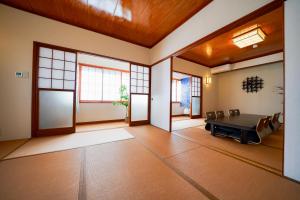 Großes Zimmer mit einem Tisch und Stühlen. in der Unterkunft KeiCo 定員12名 駐車場12台 露天風4分 河口湖6分 富士急10分 ふじてんスノーリゾート10分 in Narusawa