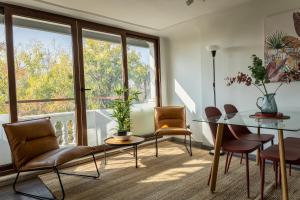 a dining room with a glass table and chairs at Apart Hotel Dresden in Santiago