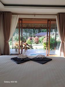 a bedroom with a bed with two robes on it at Bulan Villa Koh Yao Noi in Ban Laem Sai