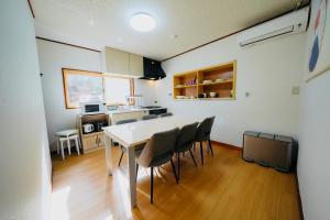 a kitchen and dining room with a table and chairs at KeiCo 定員12名 駐車場12台 露天風4分 河口湖6分 富士急10分 ふじてんスノーリゾート10分 in Narusawa