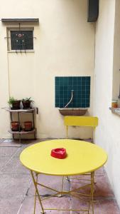 ein gelber Tisch mit einem roten Hut darauf in der Unterkunft Faenza Apartments by Console Camprini Estates srl in Faenza + 9 Fotos