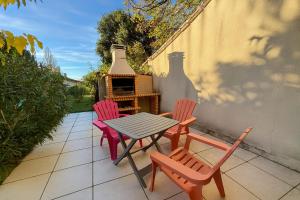 3 Stühle und ein Tisch auf einer Terrasse in der Unterkunft La Coccinelle- Gîte familial, Spa & Sauna in Lafrançaise