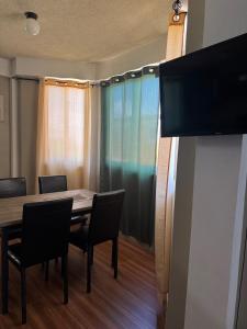 ein Esszimmer mit Tisch und Stühlen und einem Fernseher in der Unterkunft MJay's Studio in Paix Bouche