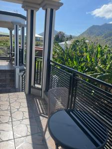 einen Tisch und einen Stuhl auf einem Balkon mit Aussicht in der Unterkunft MJay's Studio in Paix Bouche