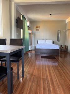 ein Schlafzimmer mit einem Bett, einem Tisch und einem Tisch in der Unterkunft MJay's Studio in Paix Bouche