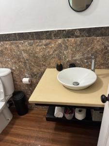 ein Badezimmer mit einem weißen Waschbecken auf einer Ablage in der Unterkunft MJay's Studio in Paix Bouche + 3 Fotos