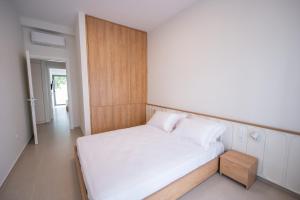 a small bedroom with a bed and a wooden wall at Michail Old Harbour Residence in Kos