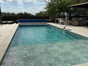 une piscine avec de l'eau bleue dans une cour arrière dans l'établissement גרין פארק - קוטג' מהמם עם בריכה מחוממת וג'קוזי בעין קנייא, à Ein Kinya 9 autres photos