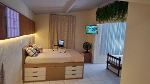 a bedroom with a bed with a laptop on it at Vilars154 - Cavaleiros e Lagoa in Macaé