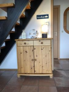 une armoire en bois dans une pièce avec un escalier dans l'établissement Tossi Haus 107 In Fedderwardersiel, à Butjadingen