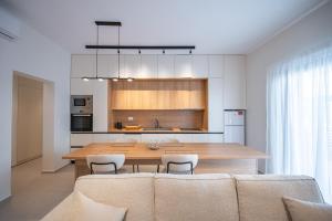 a kitchen and dining room with a large wooden table at Michail Old Harbour Residence in Kos