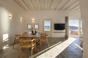 a dining room with a table and chairs and a tv at New Project Fos in Platis Yialos Sifnos