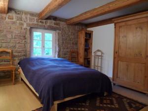 ein Schlafzimmer mit einem Bett und einer Steinwand in der Unterkunft Ferienhaus In Walscheid Mit Terrasse, Grill in Walscheid