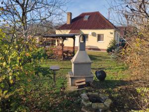 ein Haus mit einem Denkmal vor dem Hof in der Unterkunft Akácvirág Vendégház in Ács + 9 Fotos