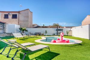 ein Garten mit Pool, Stühlen und einem rosa Schwan in der Unterkunft VILLA T to15 min from Puy du Fou Billiar, Movies, BBQ,Pool in Totanés