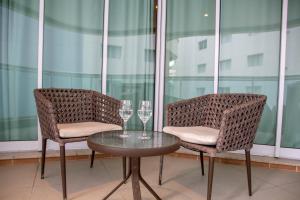 zwei Stühle und ein Tisch mit zwei Weingläsern in der Unterkunft BookSantos Estanconfor 1007 - Perto do mar Gonzaga in Santos