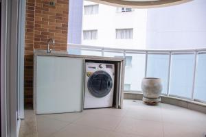 eine Waschmaschine und einen Trockner in einem Zimmer mit Balkon in der Unterkunft BookSantos Estanconfor 1007 - Perto do mar Gonzaga in Santos