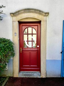 eine rote Tür eines Gebäudes mit einem Schild darauf in der Unterkunft COC - Basse Mer in Wissant