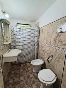ein Badezimmer mit Toilette und Waschbecken in der Unterkunft Casa exclusiva con pile in San Antonio de Arredondo
