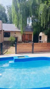 ein blauer Pool neben einer Holzbank in der Unterkunft Casa exclusiva con pile in San Antonio de Arredondo