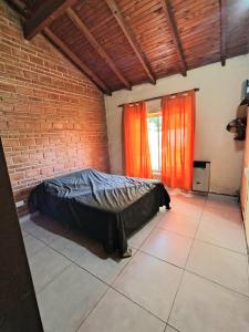 ein Schlafzimmer mit einem Bett in einer Ziegelwand in der Unterkunft Casa exclusiva con pile in San Antonio de Arredondo