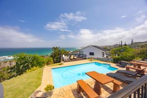 a swimming pool with a view of the ocean at Beachcomber Bay Guest House In South Africa in Margate