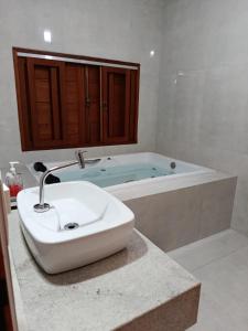 a bathroom with a sink and a bath tub at Casa Limoeiro in Pirenópolis +52 photos