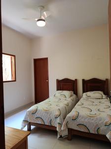 a bedroom with two beds and a table at Casa Limoeiro in Pirenópolis