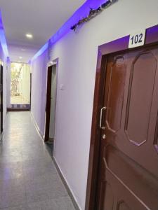 Un pasillo con una puerta con un cartel. en Hotel vishram, en Aligarh